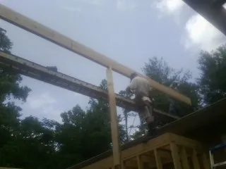 Carpenter setting a ridge beam over a new addition frame — Ice Dam Removal by Roofing Brothers in Ardsley On Hudson
