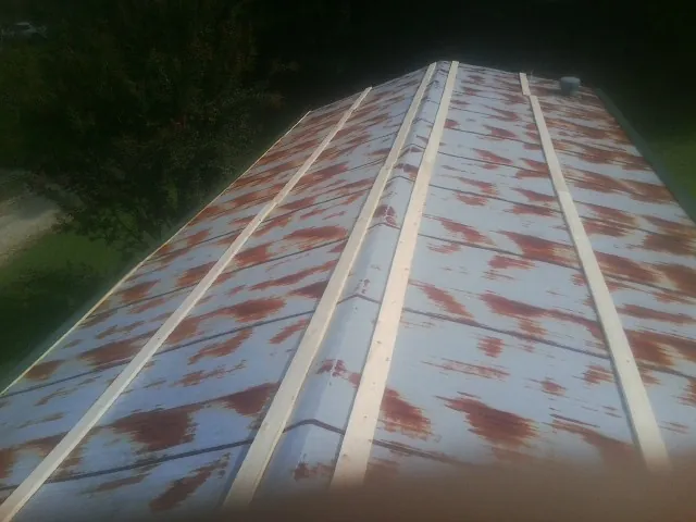 Rusted metal roof panels with new wood purlins before replacement — Storm Damage Roof Repair in Ardsley On Hudson by Roofing Brothers
