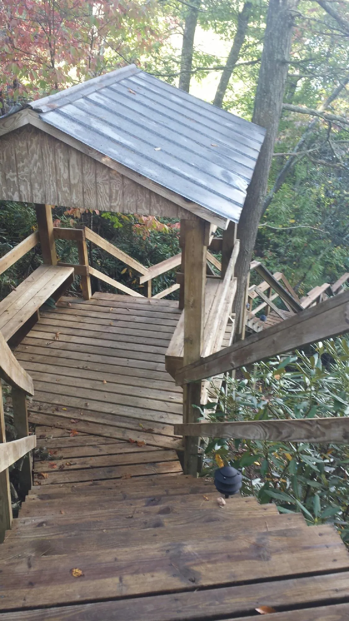 Metal roofed shelter over wooden steps on a wooded walkway — Skylight Repair & Installation work by our crew in Ardsley On Hudson